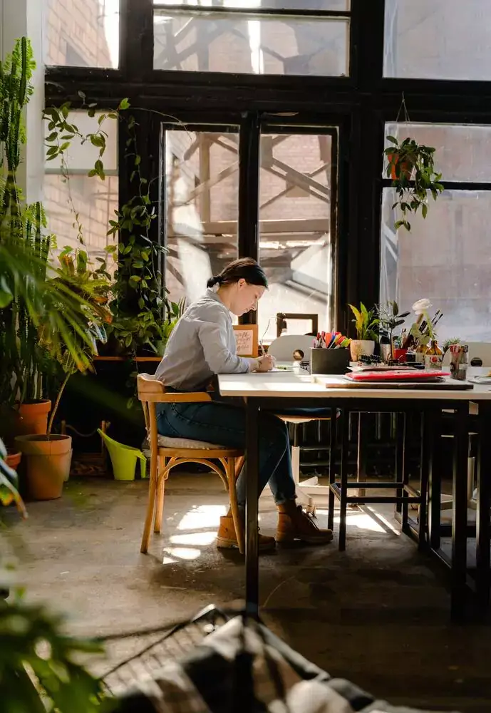 A woman sitting at a table taking notes on the roles of psychologists, psychiatrists and therapists.