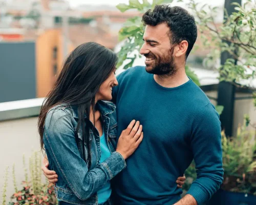 A high-achieving married couple in couples therapy embracing each other.